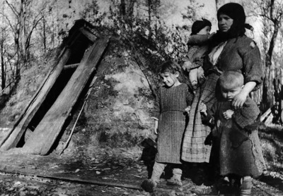 Белорусская крестьянка с детьми у входа в свою землянку, 1942 год, фотохроника ВОВ