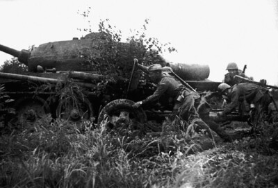 Расчет советской 76-мм пушки ЗиС-3 меняет позицию на Сахалине у танка Т-34-85