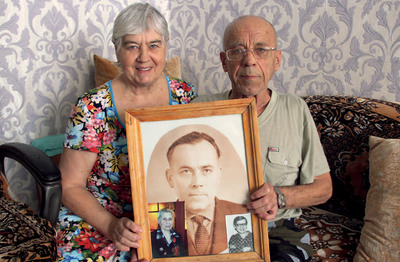 Виктор Львов и его жена Светлана с портретом родителей, Холмск, 2023 год