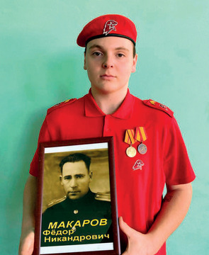 Двоюродный внук Семён Лихачёв держит фотографию деда Фёдора Макарова