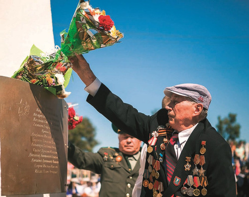 Николай Иванович Ступак возлагает цветы к памятнику советским воинам в городе Холмске